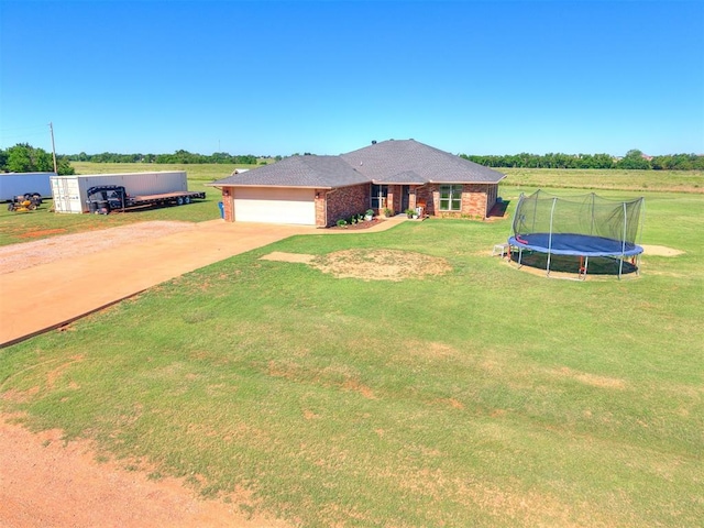5053 Northridge Run, Cashion, OK 73016 - ranch-style house featuring a trampoline, driveway, a front lawn, and a garage