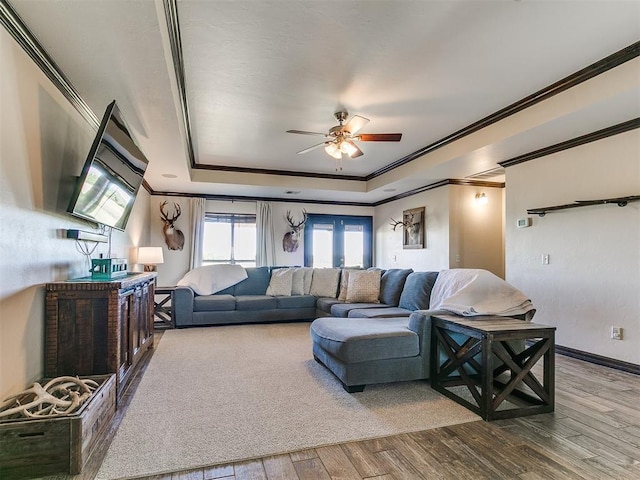 5053 Northridge Run, Cashion, OK 73016 - living room featuring ornamental molding, a tray ceiling, a ceiling fan, and wood finished floors