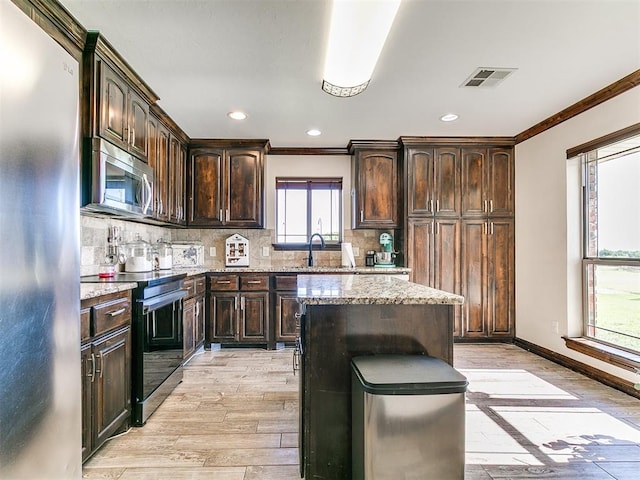 5053 Northridge Run, Cashion, OK 73016 - kitchen with stainless steel appliances, ornamental molding, light stone countertops, light wood finished floors, and tasteful backsplash