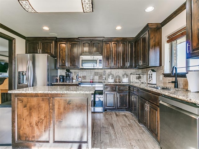 5053 Northridge Run, Cashion, OK 73016 - kitchen featuring stainless steel appliances, ornamental molding, light wood-style flooring, a center island, and dark brown cabinets