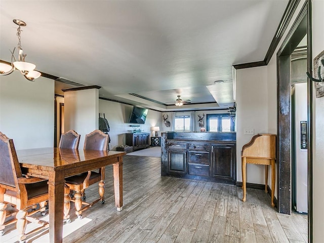 5053 Northridge Run, Cashion, OK 73016 - dining room featuring light wood-style flooring, a ceiling fan, a chandelier, a tray ceiling, and crown molding