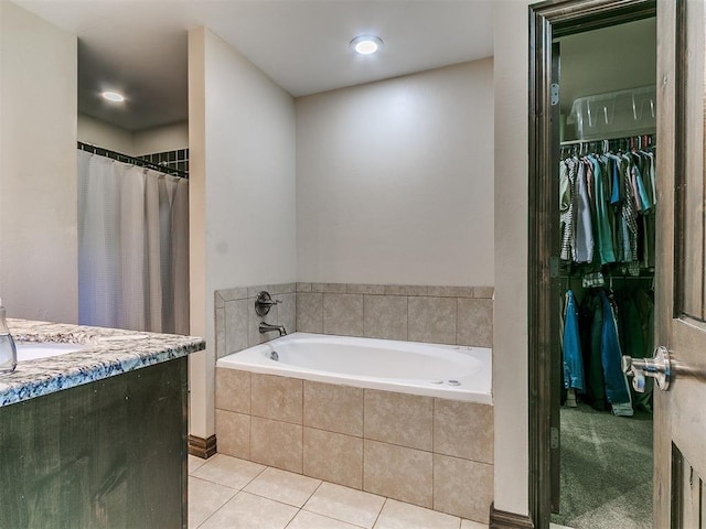 5053 Northridge Run, Cashion, OK 73016 - bathroom featuring a garden tub, a walk in closet, tile patterned flooring, and vanity