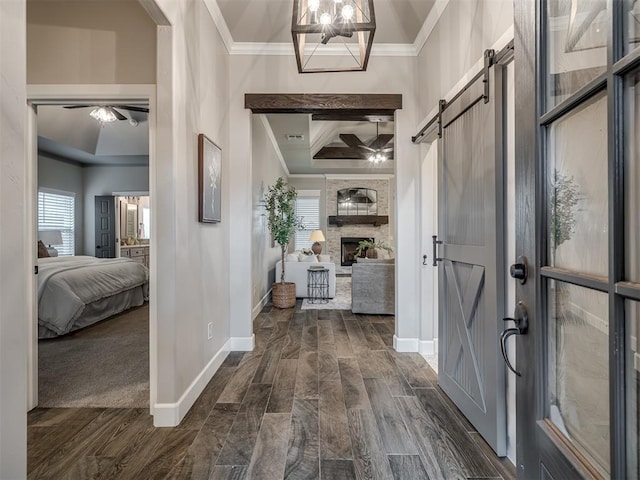 11716 SW 47th St, Mustang, OK 73064 - entrance foyer with crown molding, a barn door, a ceiling fan, dark wood-style flooring, and a large fireplace