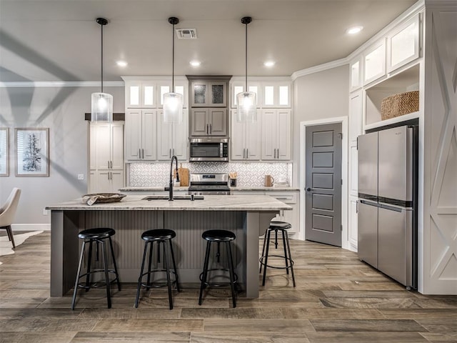 11716 SW 47th St, Mustang, OK 73064 - kitchen with appliances with stainless steel finishes, crown molding, backsplash, a kitchen breakfast bar, and glass insert cabinets