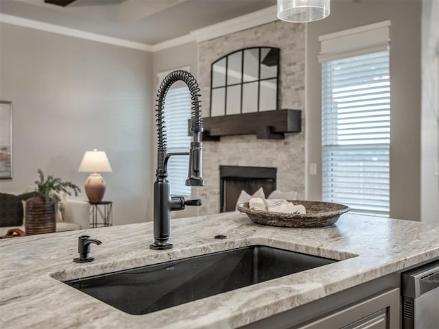 11716 SW 47th St, Mustang, OK 73064 - kitchen featuring a fireplace, crown molding, light stone counters, dishwashing machine, and pendant lighting