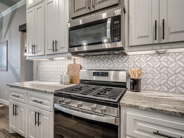 11716 SW 47th St, Mustang, OK 73064 - kitchen featuring appliances with stainless steel finishes, backsplash, light stone counters, and white cabinetry