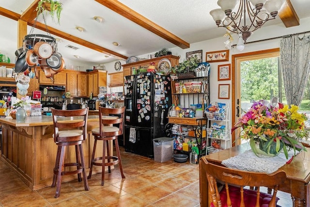 12333 E Tecumseh Rd, Norman, OK 73026 - kitchen with black appliances, a chandelier, beam ceiling, light tile patterned floors, and brown cabinets