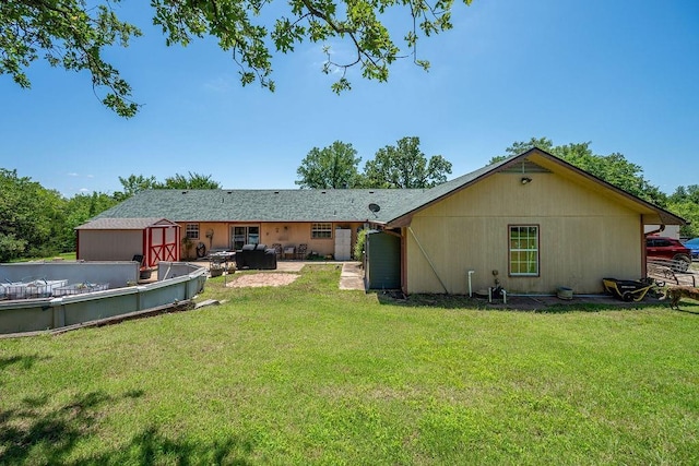 12333 E Tecumseh Rd, Norman, OK 73026 - rear view of property featuring a storage unit, a yard, and a patio