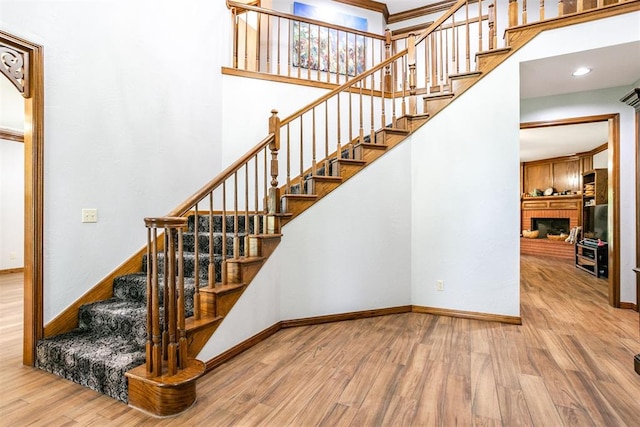 11748 SW 54th St, Mustang, OK 73064 - stairway with wood finished floors, a towering ceiling, and a fireplace