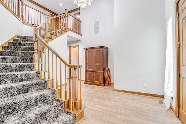 11748 SW 54th St, Mustang, OK 73064 - stairs featuring wood finished floors, a chandelier, a towering ceiling, and ornamental molding