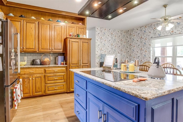 11748 SW 54th St, Mustang, OK 73064 - kitchen featuring freestanding refrigerator, black electric cooktop, light wood finished floors, backsplash, and ceiling fan