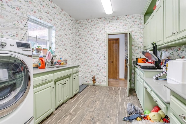 11748 SW 54th St, Mustang, OK 73064 - washroom with washer / clothes dryer, wallpapered walls, light wood finished floors, and cabinet space