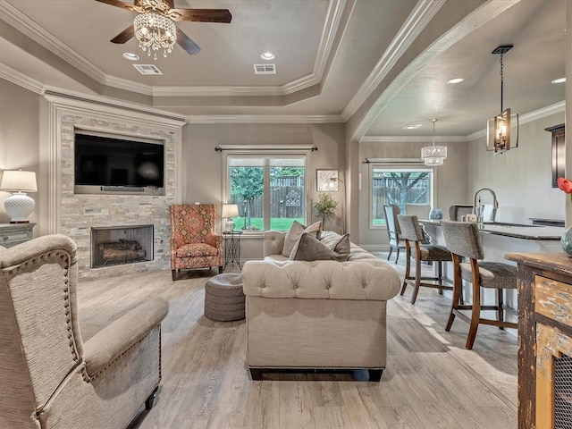 16117 Cale Dr, Edmond, OK 73013 - living room with a ceiling fan, wood finished floors, a fireplace, a chandelier, and crown molding