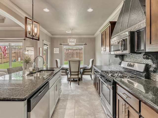 16117 Cale Dr, Edmond, OK 73013 - kitchen with appliances with stainless steel finishes, a chandelier, backsplash, dark stone counters, and pendant lighting
