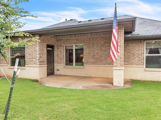 16117 Cale Dr, Edmond, OK 73013 - rear view of house with brick siding, a patio area, and a lawn