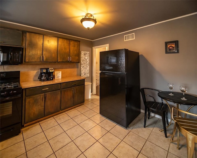 4117 NW 21st St, Oklahoma City, OK 73107 - kitchen with black appliances, light tile patterned flooring, light countertops, dark brown cabinets, and crown molding