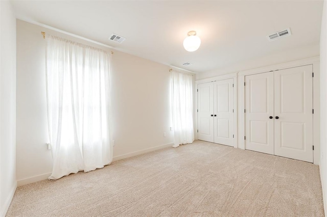 406 E Logan Ave, Guthrie, OK 73044 - unfurnished bedroom with multiple closets, carpet, and multiple windows