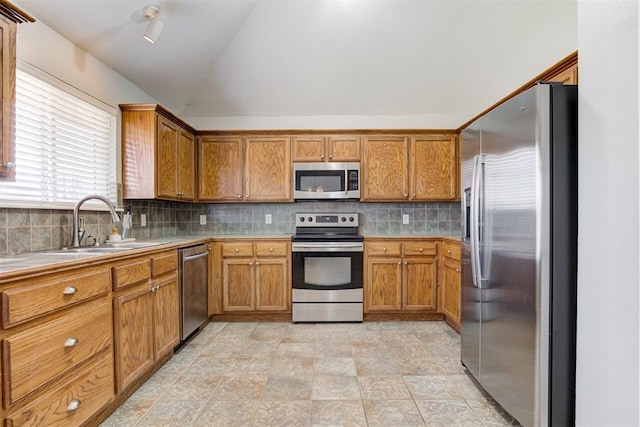21854 Meadow Mist Cir, Edmond, OK 73012 - kitchen featuring stainless steel appliances, lofted ceiling, brown cabinetry, backsplash, and light countertops