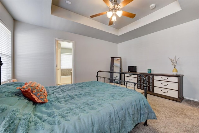 21854 Meadow Mist Cir, Edmond, OK 73012 - carpeted bedroom with a raised ceiling, a ceiling fan, and ensuite bathroom