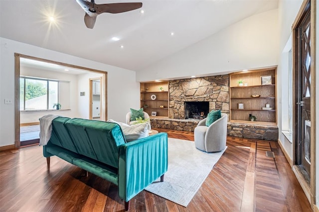 3425 Cheyenne Dr, Edmond, OK 73013 - living area featuring lofted ceiling, wood finished floors, a ceiling fan, a stone fireplace, and built in shelves