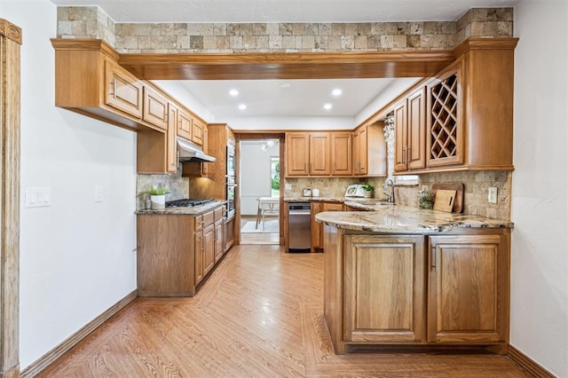 3425 Cheyenne Dr, Edmond, OK 73013 - kitchen featuring light stone countertops, light wood-style flooring, tasteful backsplash, and a peninsula