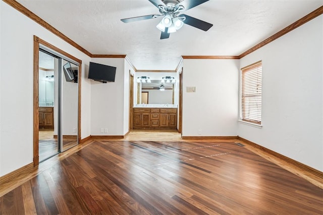 3425 Cheyenne Dr, Edmond, OK 73013 - unfurnished bedroom featuring wood finished floors, connected bathroom, crown molding, a textured ceiling, and a ceiling fan