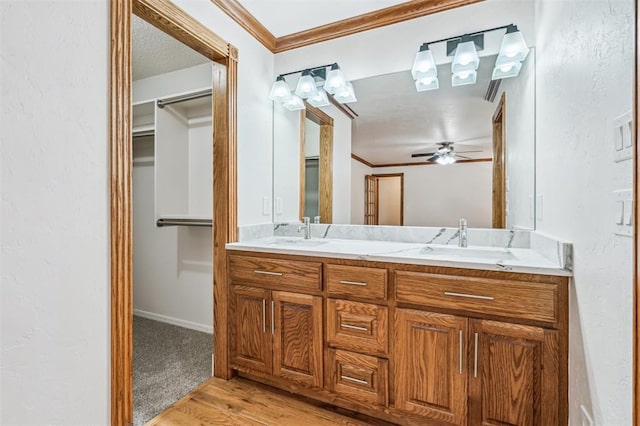 3425 Cheyenne Dr, Edmond, OK 73013 - full bathroom with double vanity, wood finished floors, ceiling fan, ornamental molding, and a spacious closet