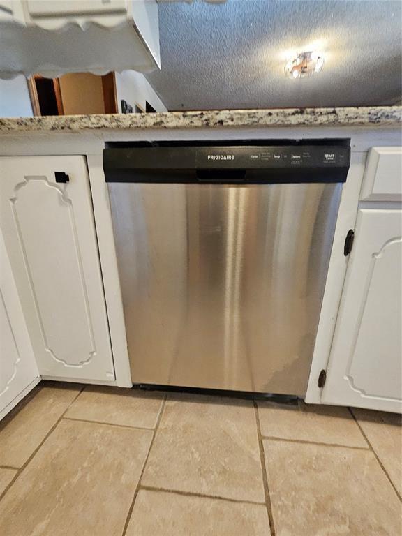 321 W 4th St, Hobart, OK 73651 - kitchen view of stainless steel dishwasher, white cabinets, and light countertops