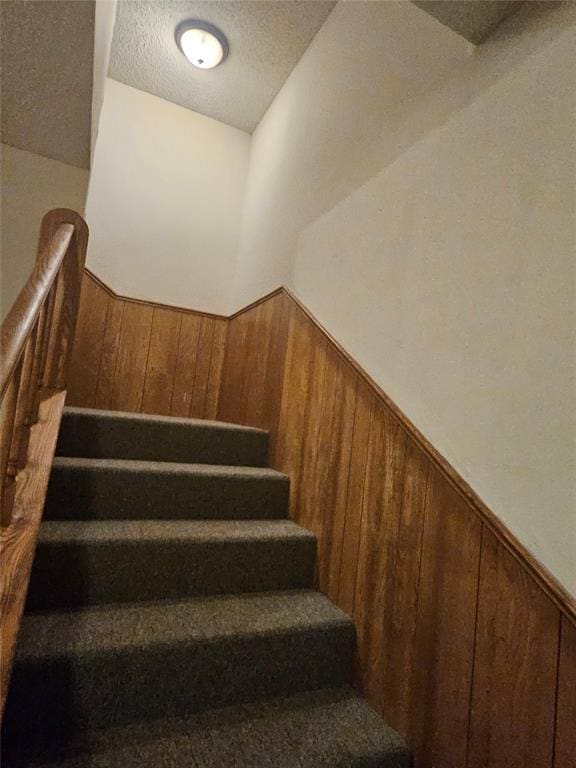 321 W 4th St, Hobart, OK 73651 - stairway with a wainscoted wall, wood walls, and a textured ceiling