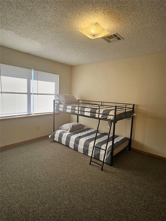 321 W 4th St, Hobart, OK 73651 - bedroom featuring a textured ceiling and carpet flooring