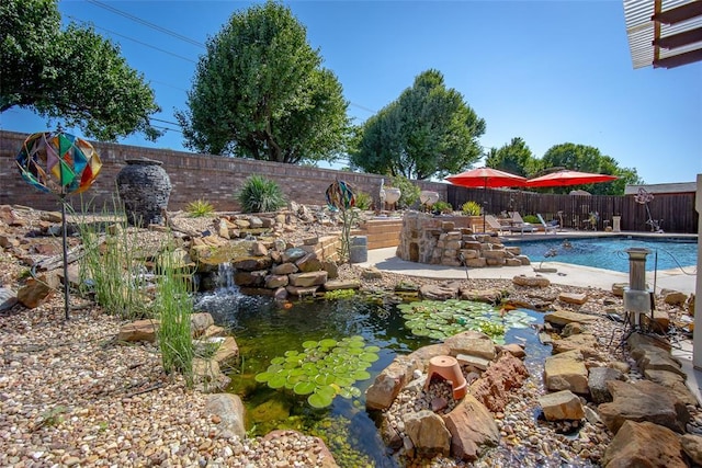 9124 SW 28th St, Oklahoma City, OK 73128 - view of swimming pool with a fenced backyard and a small pond