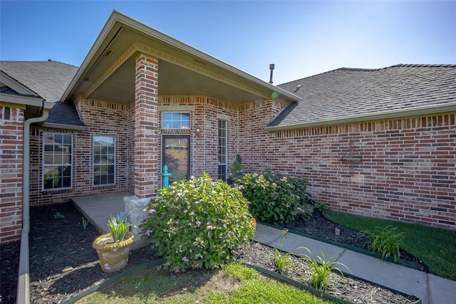 9124 SW 28th St, Oklahoma City, OK 73128 - entrance to property featuring brick siding, roof with shingles, and a patio area