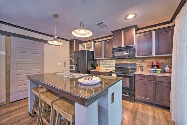 86 Crooked Oaks Ln, Broken Bow, OK 74728 - kitchen featuring black appliances, wood finished floors, ornamental molding, backsplash, and a kitchen island with sink
