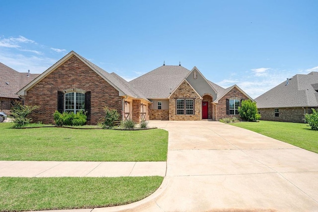 3000 Warwick Pl, Edmond, OK 73013 - french country style house with concrete driveway, brick siding, a front lawn, and roof with shingles
