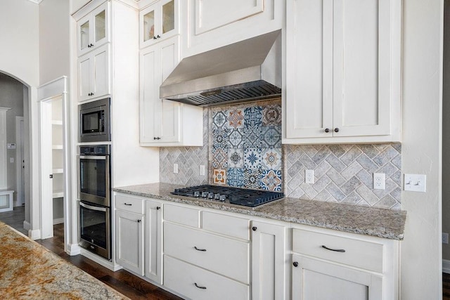 3000 Warwick Pl, Edmond, OK 73013 - kitchen with wall chimney range hood, appliances with stainless steel finishes, white cabinets, and arched walkways