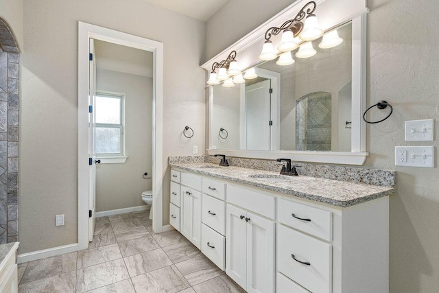 3000 Warwick Pl, Edmond, OK 73013 - bathroom with double vanity, marble look tile flooring, and a chandelier