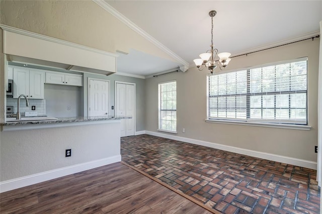 16408 Del Mar Dr, Edmond, OK 73013 - kitchen featuring a chandelier, ornamental molding, tasteful backsplash, vaulted ceiling, and white cabinets