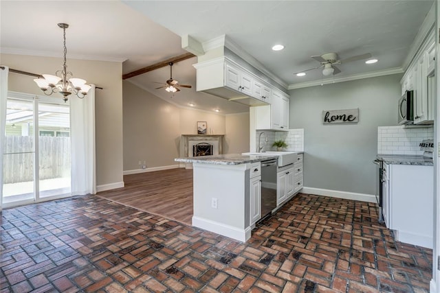 16408 Del Mar Dr, Edmond, OK 73013 - kitchen with a ceiling fan, appliances with stainless steel finishes, crown molding, a peninsula, and a fireplace with raised hearth