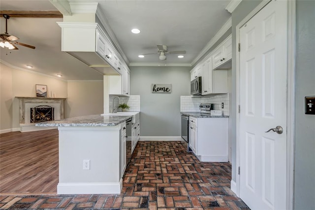 16408 Del Mar Dr, Edmond, OK 73013 - kitchen with ceiling fan, stainless steel appliances, decorative backsplash, crown molding, and white cabinetry