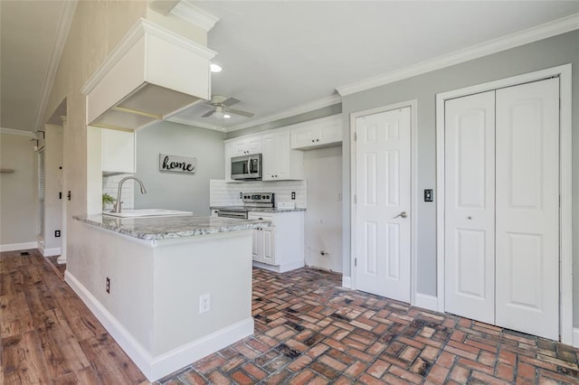 16408 Del Mar Dr, Edmond, OK 73013 - kitchen with appliances with stainless steel finishes, ceiling fan, decorative backsplash, ornamental molding, and white cabinetry