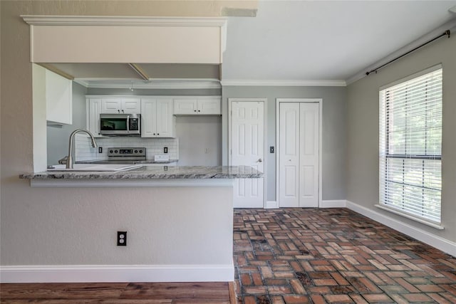 16408 Del Mar Dr, Edmond, OK 73013 - kitchen with appliances with stainless steel finishes, crown molding, brick flooring, decorative backsplash, and white cabinetry