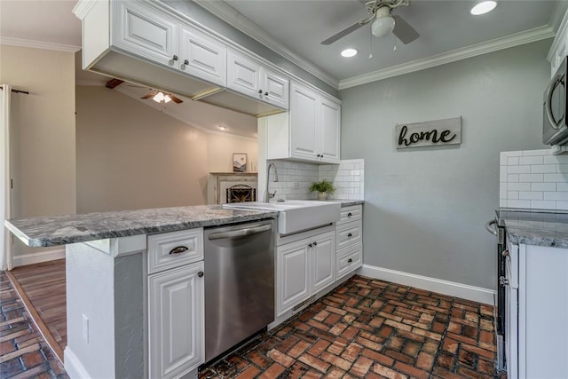 16408 Del Mar Dr, Edmond, OK 73013 - kitchen featuring stainless steel dishwasher, a ceiling fan, a peninsula, brick flooring, and white cabinetry