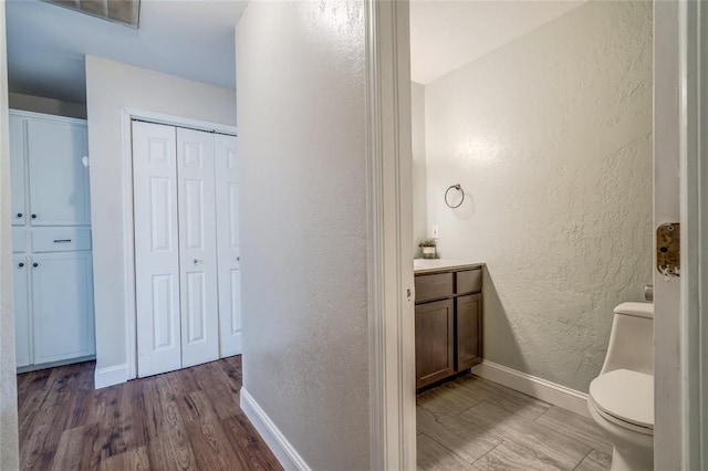 16408 Del Mar Dr, Edmond, OK 73013 - bathroom featuring a textured wall, a closet, vanity, and wood finished floors
