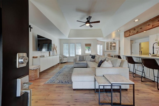 1001 Fountain Gate Cir, Norman, OK 73072 - living room featuring ceiling fan, a raised ceiling, light wood-style floors, a barn door, and recessed lighting
