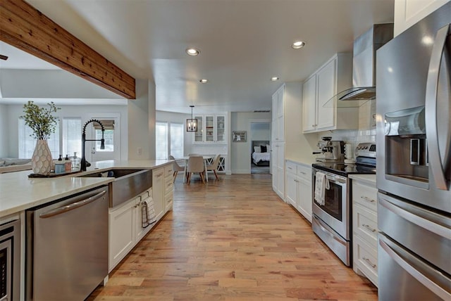 1001 Fountain Gate Cir, Norman, OK 73072 - kitchen with appliances with stainless steel finishes, wall chimney range hood, white cabinets, recessed lighting, and light countertops