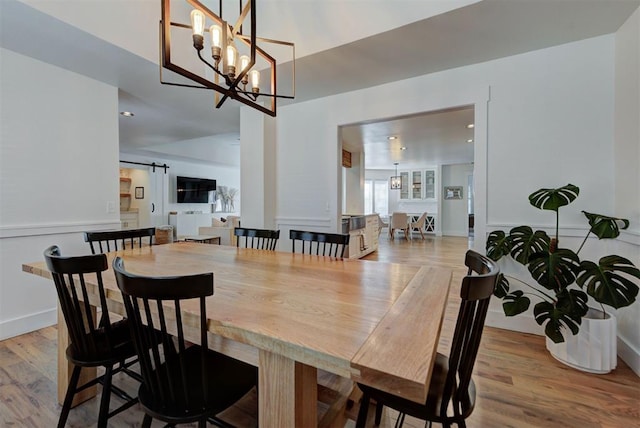 1001 Fountain Gate Cir, Norman, OK 73072 - dining space with a barn door, wood finished floors, a chandelier, and recessed lighting