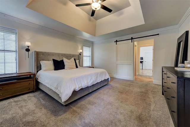 1001 Fountain Gate Cir, Norman, OK 73072 - carpeted bedroom featuring a tray ceiling, a barn door, crown molding, and ceiling fan