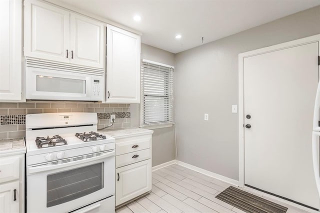 3020 NW 71st St, Oklahoma City, OK 73116 - kitchen featuring white appliances, light countertops, tasteful backsplash, white cabinetry, and recessed lighting