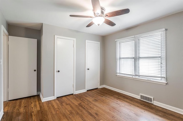 3020 NW 71st St, Oklahoma City, OK 73116 - unfurnished bedroom featuring multiple closets, wood finished floors, and ceiling fan