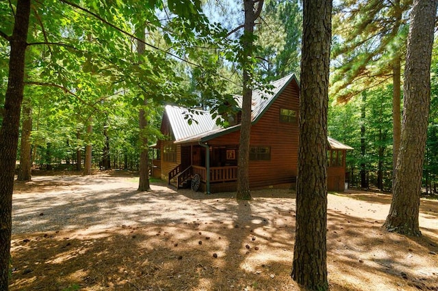 244 Hiddenwater Rd, Broken Bow, OK 74728 - view of front facade with covered porch, a metal roof, and dirt driveway